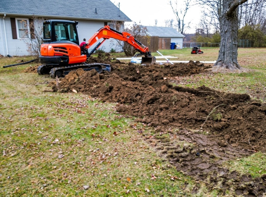 Excavator digging a septic leach field trench in the yard of a Champaign County Ohio home